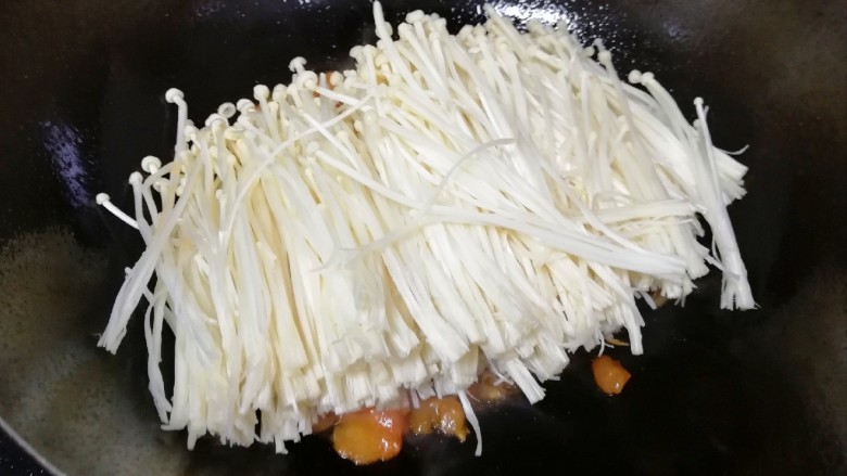 茄汁金针菇,下入金针菇翻炒均匀。