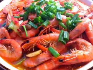 水煮香辣虾,把煮好的明虾连汤一起倒入放莴笋的大碗里，放上葱叶。