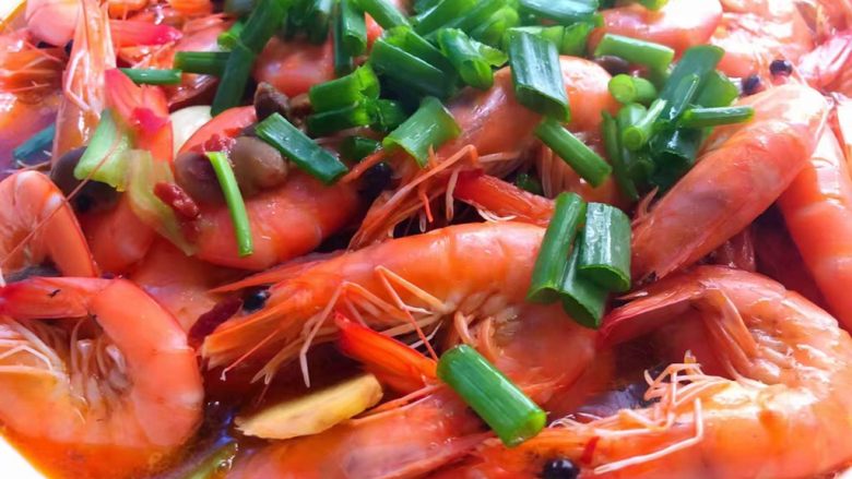 水煮香辣虾,把煮好的明虾连汤一起倒入放莴笋的大碗里，放上葱叶。