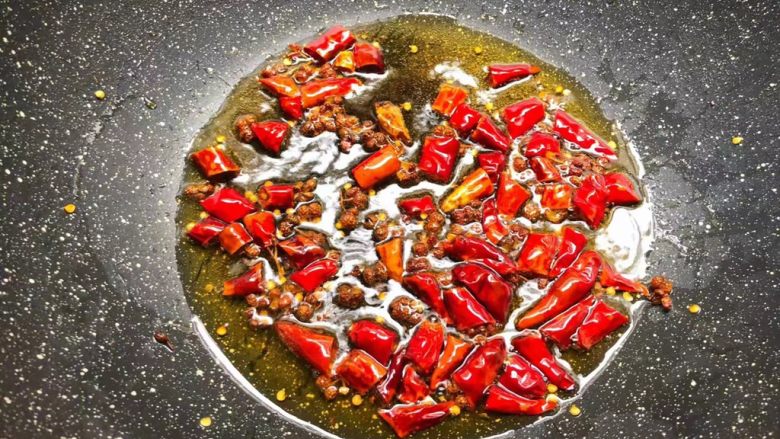 水煮香辣虾,锅里放入适量油烧热，把花椒和干辣椒放入煸炒出香味。