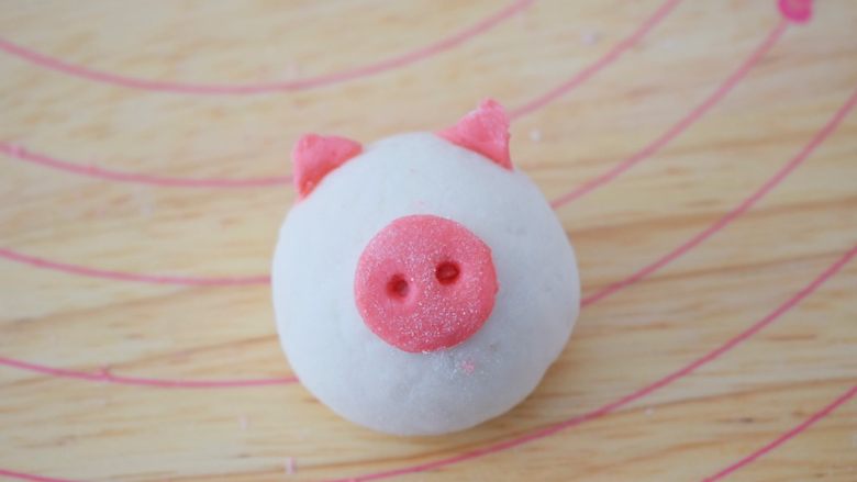 小猪花生流沙汤圆,取一个包好的汤圆，把猪鼻子和耳朵沾上水装上