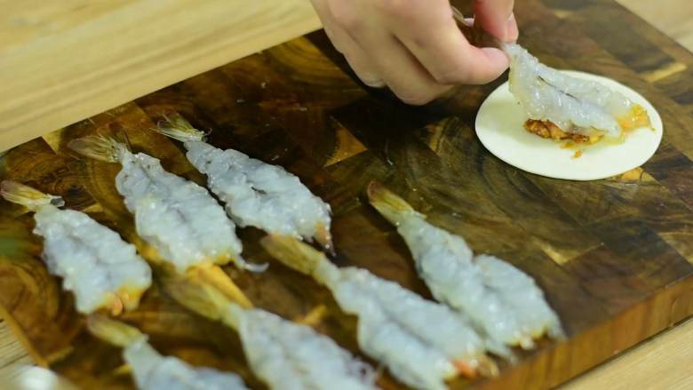 光是看着都流口水的大虾抱蛋煎饺,饺子皮先铺上肉馅，再摆上大虾。