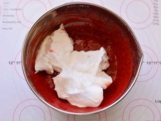 红丝绒蛋糕卷,取1/3蛋白霜放入蛋黄糊中，用刮刀画Z字形快速翻拌均匀，过程要轻，要快。
