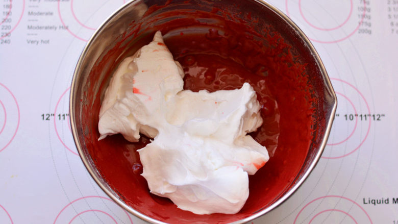 红丝绒蛋糕卷,取1/3蛋白霜放入蛋黄糊中，用刮刀画Z字形快速翻拌均匀，过程要轻，要快。
