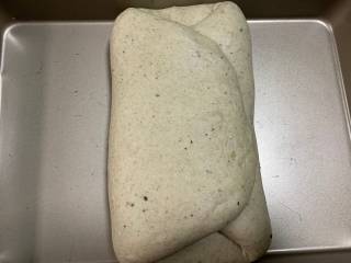 芝士培根软欧面包,面团打发好后，放入烤盘压扁折叠，如图折叠后再上下折叠下。28度75%湿度发酵30分钟后，再重复此步骤一次。