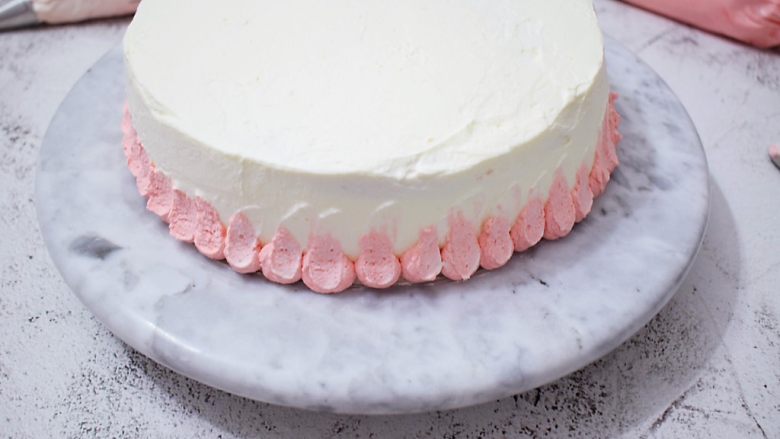 皇冠彩虹蛋糕,然后先在蛋糕底部用粉色挤出圆点，再用小刀在奶油往上抹去，形成一个水滴