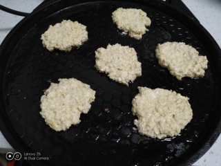 燕麦鸡蛋小饼,电饼铛中放入适量油，用勺子挖入，再用勺子压成饼。