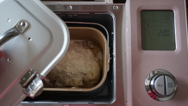 面包机版炼奶面包,再倒入90克面粉，将面包桶放入到东菱JD08面包机里，盖上面包桶的盖子，防止和面时面粉飞溅出来，选择和面程序10分钟