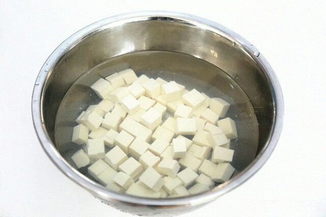 蟹黄豆腐,把豆腐切成小块，然后放入淡盐水中浸泡10分钟。
