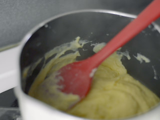 入口即溶烫面双重芝士轻乳酪,将蛋黄糊倒回奶锅，小火，搅拌，直到变成卡仕达酱的样子