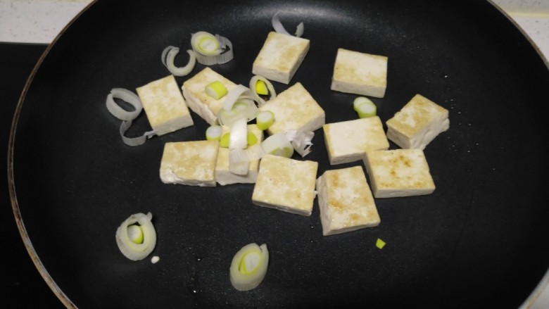 豆腐炒香菇,煎至两面金黄，撒入葱碎。