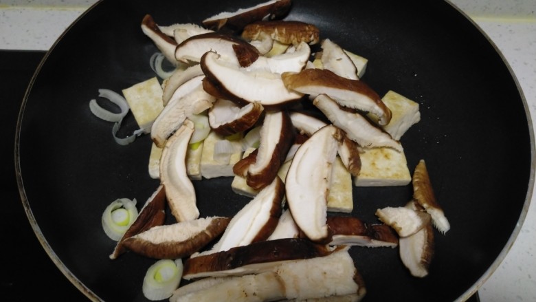 豆腐炒香菇,倒入香菇。
