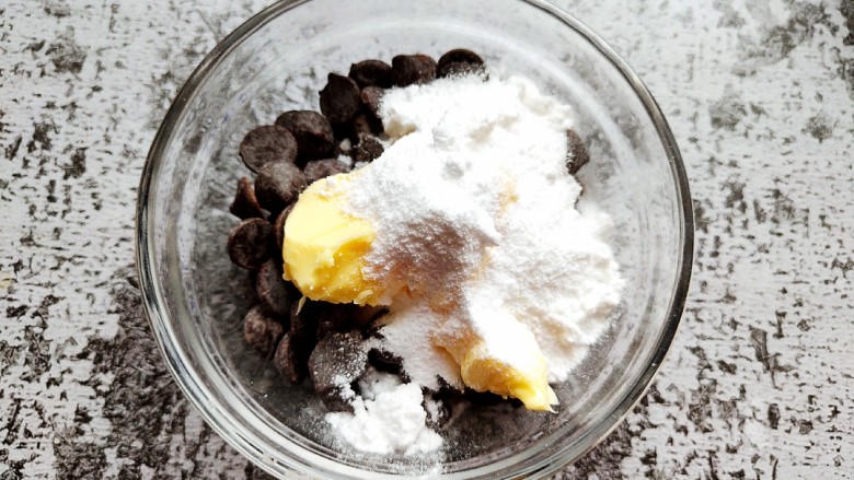 巧克力流心汤圆,巧克力放入碗中，加入软化的黄油和糖粉。
