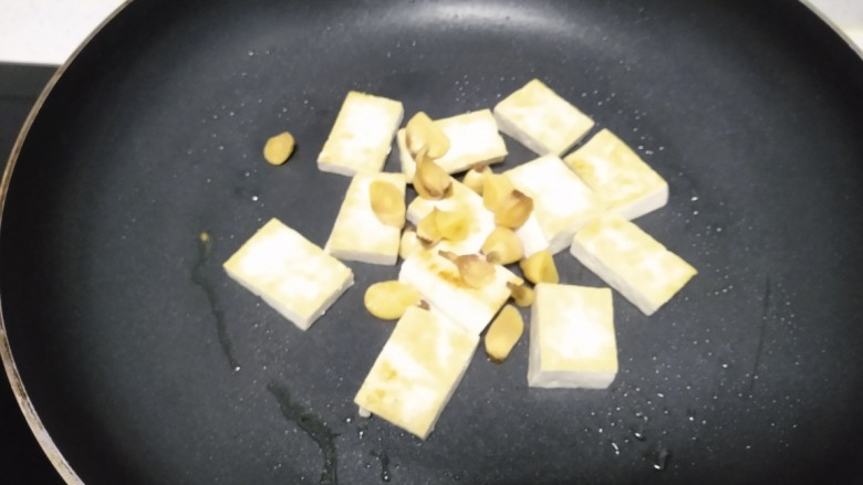 豆腐炒胡萝卜西兰花茎,放入蒜片。