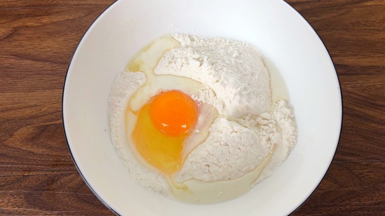快手华夫饼,把松饼粉倒入大一点的碗里，磕入一个鸡蛋，再倒入40克牛奶。