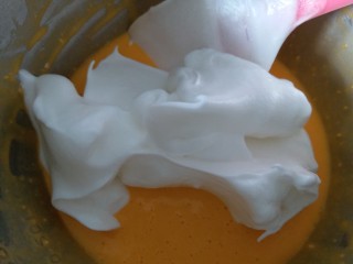 咸蛋黄肉松盒子蛋糕,分三分之一的蛋白霜到蛋黄糊内，用刮刀翻拌均匀。