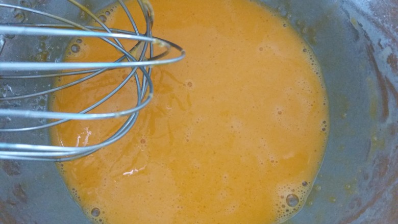咸蛋黄肉松盒子蛋糕,先把油放进蛋黄内，用手动打蛋器搅拌均匀。再加入纯净水搅拌均匀。