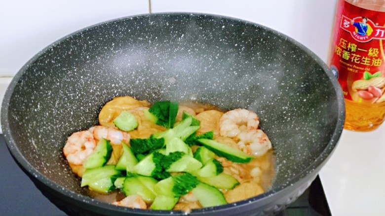 好吃到舔盘子的～金牌虾仁炒面筋,再加入切好的黄瓜，按个人口味加入盐翻炒均匀。