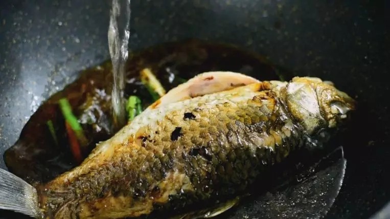 教你“葱烧鲫鱼”的做法,非常美味的家常菜,.放入鲫鱼，加入料酒、老抽、白糖、清水