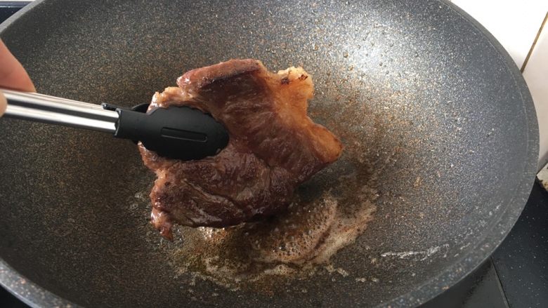 红酒黑胡椒牛排,最后用夹子夹住板腱牛排将侧面略微煎一下即可出锅。