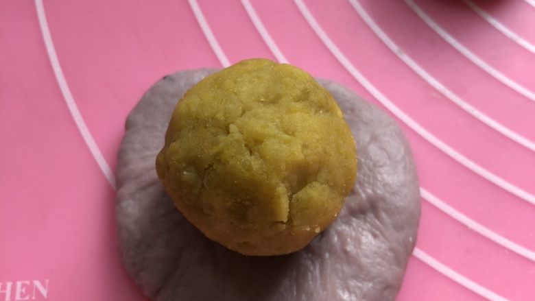 桑葚汁雪蜜红薯小面包,每个小面团压扁擀开成一个圆形。翻面，包入馅料。