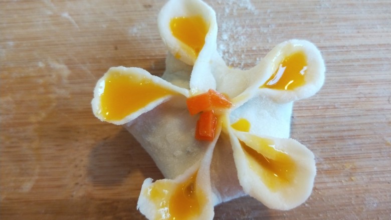 蛋液灌饺  新文美食,灌好的近看一下，中间点一下蛋黄，撒上胡萝卜碎。