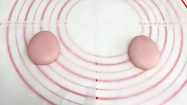 小福猪中国结馒头,淡粉色面团预留1～2克做耳朵，其余均分成两份，按图上整理成水滴状的造型做小猪主体。