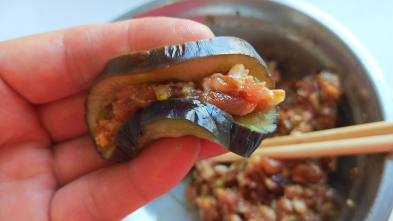 肉末蒸茄子 新文美食,放入馅料对折如图所示。