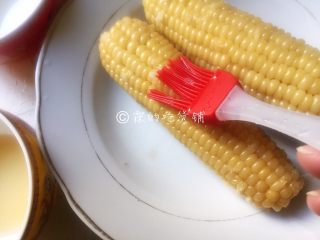奶香烤玉米,用刷子先刷一层蜂蜜水到玉米上，让它自然吹干个1分钟左右，