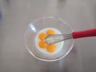 海苔肉松戚风蛋糕,将4个鸡蛋蛋清跟蛋黄分开，将蛋黄加入牛奶里搅拌均匀。
