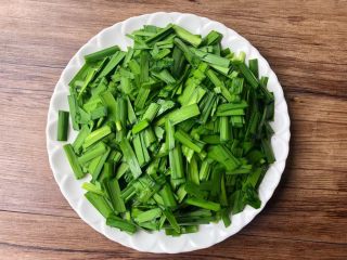 豆芽炒韭菜,韭菜摘掉黄色的叶子，清洗干净切成段，装入盘里待用。