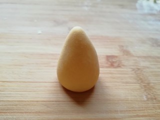 玉米粉窝窝头,取一个小剂子揉圆搓成圆锥形。