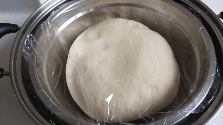 糖三角  新文美食,合成光滑的面团，封上保鲜膜放入温水锅中发酵。