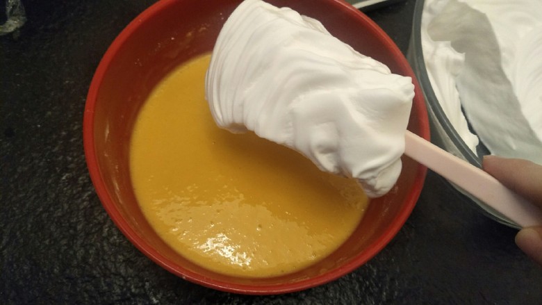 绵软细腻戚风蛋糕,挖一勺蛋白加入蛋黄中翻拌均匀。