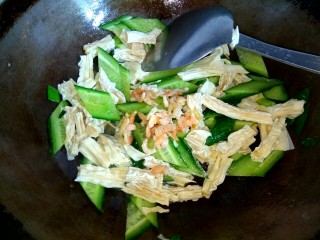 海米腐竹炒黄瓜,小碗中的海米和泡海米的水一同倒入锅中，加入适量盐