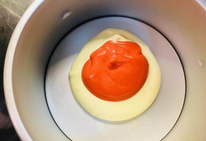 爆浆海盐红丝绒奶盖蛋糕,将混合好的蛋糊，分成两部分。其中一部分加入红丝绒精华，颜色随自己喜欢而定。用同样大小的两个勺子，取原色蛋糊放置与模具中间位置，再区一勺红色蛋糊放置与原色蛋糊之上。以此类推。