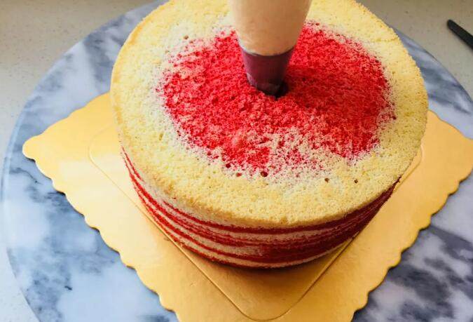 爆浆海盐红丝绒奶盖蛋糕,用刀，斜插进蛋糕中间位置。转圈划一下蛋糕内部。将奶盖酱灌入蛋糕体中。