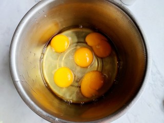 黑米海绵蛋糕,五个鸡蛋，磕入无油无水的打蛋盆中。