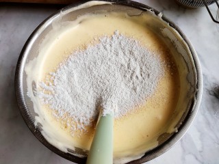 黑米海绵蛋糕,先把水和油倒里面，不用翻拌。再筛入一部分低筋面粉和黑米粉的混合，一起翻拌。