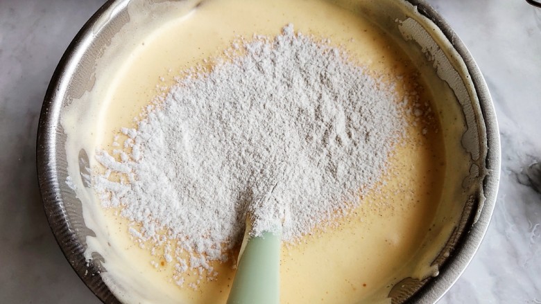 黑米海绵蛋糕,先把水和油倒里面，不用翻拌。再筛入一部分低筋面粉和黑米粉的混合，一起翻拌。