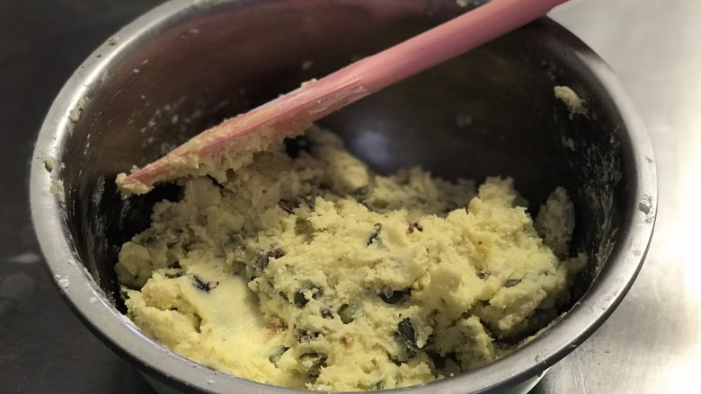 黄油饼干,筛入低粉拌匀，拌至无干粉状态，然后加入熟果仁碎拌匀。