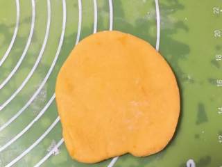 南瓜豆沙味喜饼,取出一个剂子擀成圆饼。