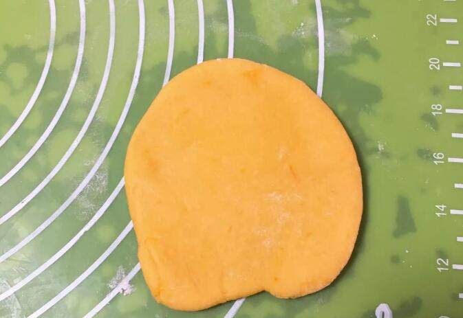 南瓜豆沙味喜饼,取出一个剂子擀成圆饼。