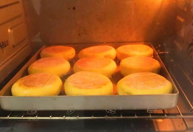 南瓜豆沙味喜饼,烤完拿出，将饼翻个身再移至金盘，放入底层烤制12分钟。