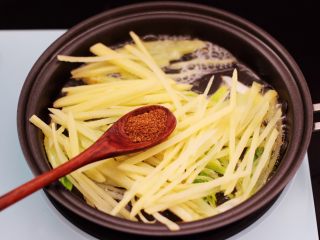 土豆丝红椒煎春卷,这个时候放入土豆丝翻炒片刻后，加入花椒粉。