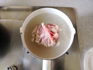 简单快手的萝卜羊肉汤,锅里烧水，水开后将解冻的羊肉卷放入焯去血沫。