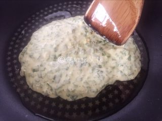 韭菜鸡蛋饼,平底锅里倒入适量的油，然后倒入一些面糊，用锅铲一点点摊圆。