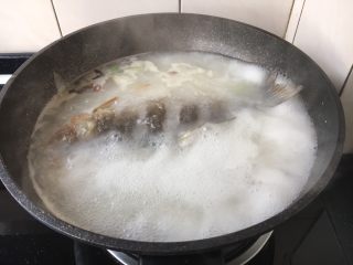 鲫鱼炖豆腐,大火煮开，中火熬至汤色变白。