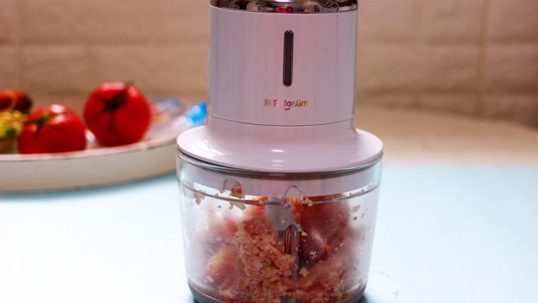 番茄肉丸汤,把切碎的葱姜和猪肉块放入东菱无线绞肉机里搅成肉泥。