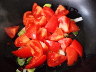 番茄肉丸汤,这个时候放入切块的番茄，大火翻炒片刻。
